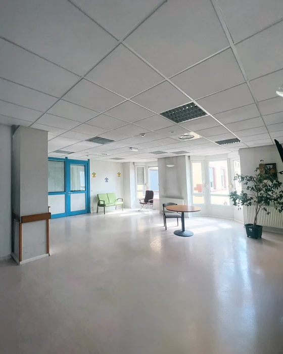 Espace d'accueil moderne avec mobilier contemporain, chaises design vertes et table ronde