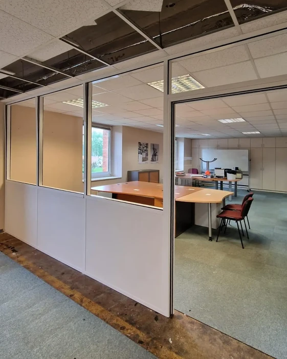 Bureau moderne avec cloisons vitrées semi-opaques délimitant un espace de travail