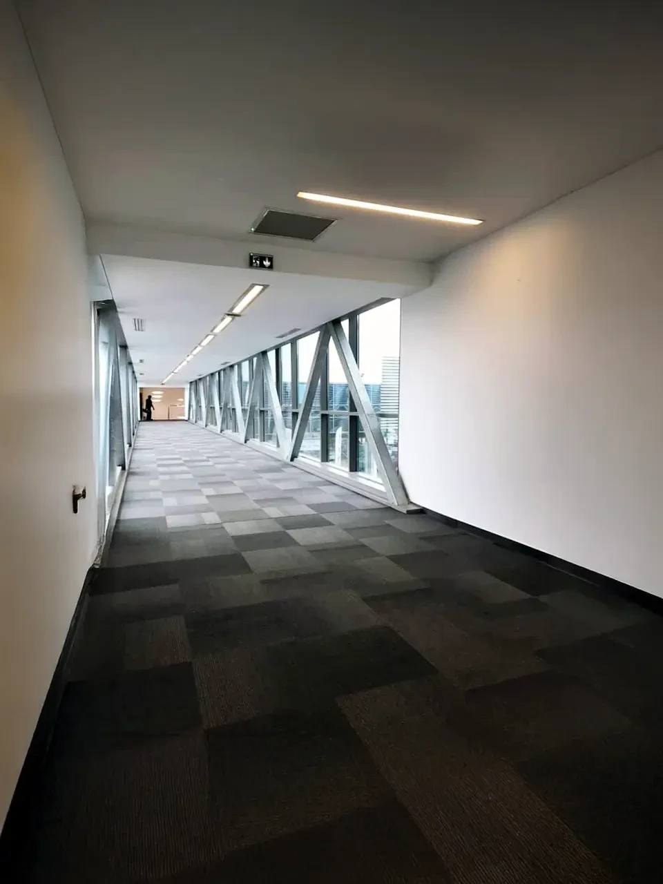 Pièce vide rénovée avec parquet chêne massif, murs blancs fraîchement peints, plafond mansardé avec poutres apparentes