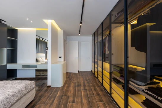 Artisan installateur en tenue de travail avec ceinture &agrave; outils ajuste une &eacute;tag&egrave;re dans un placard encastr&eacute;