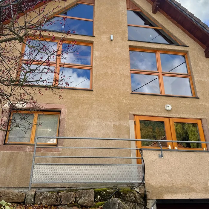 Façade d'immeuble résidentiel moderne avec balcon métallique et garde-corps en acier inoxydable