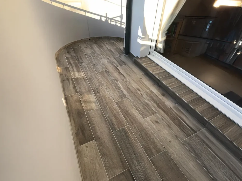 Intérieur résidentiel moderne avec sol en carrelage imitation bois gris installé en courbe