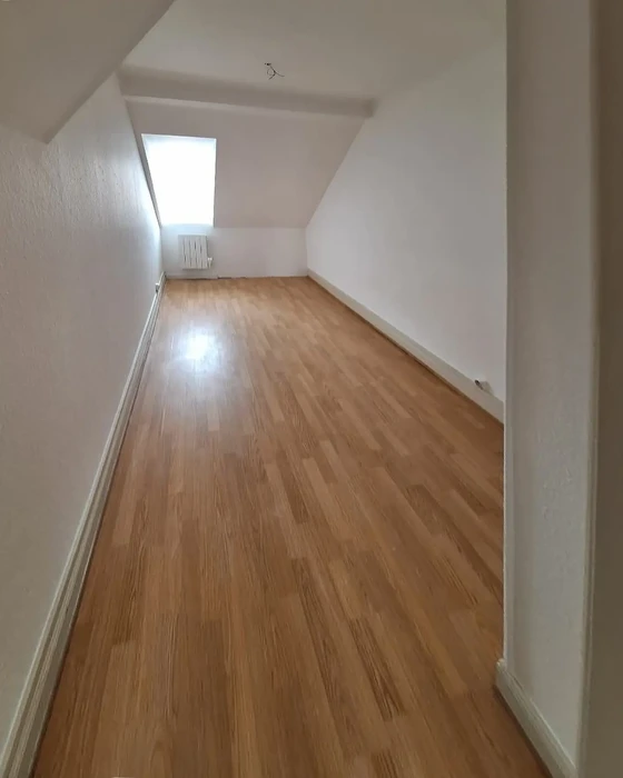 Pièce mansardée vide avec parquet flottant en chêne clair fraîchement posé