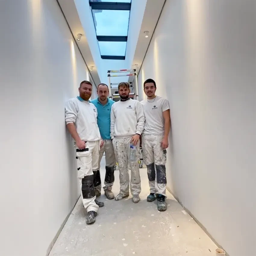 Équipe professionnelle diverse en tenue d'affaires posant ensemble dans un bureau moderne avec murs de briques apparentes