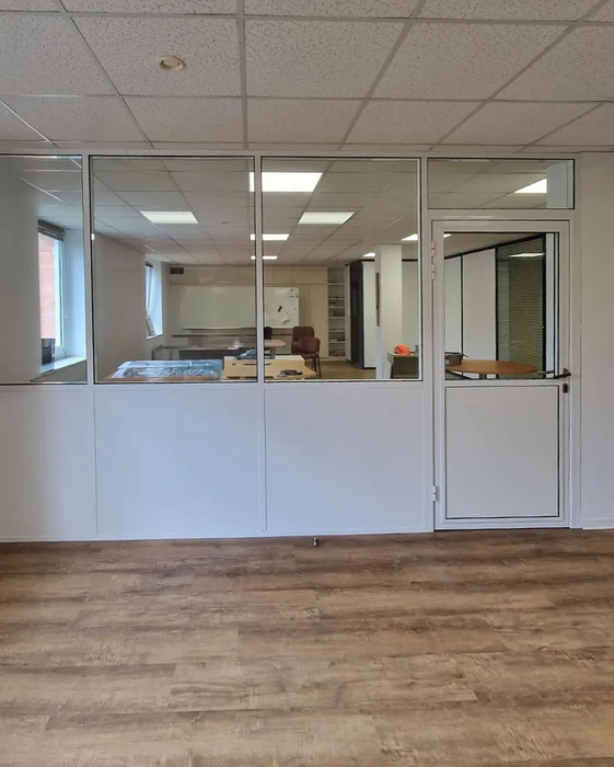 Bureau moderne avec cloisons vitrées semi-opaques délimitant un espace de travail